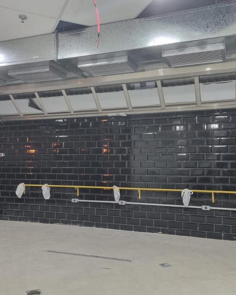 Coifas instaladas ao longo da parede de uma cozinha em obra
